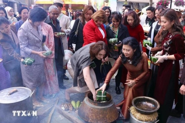 Spouse of the Party General Secretary Ngo Phuong Ly and foreign female diplomats cook 'banh chung'.