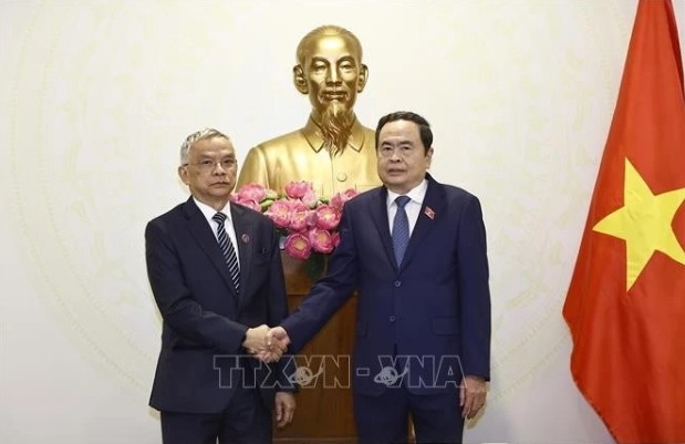 Chairman of the Vietnamese National Assembly (NA) Tran Thanh Man (R) shakes hands with Vice President of the Lao NA Sommad Pholsena