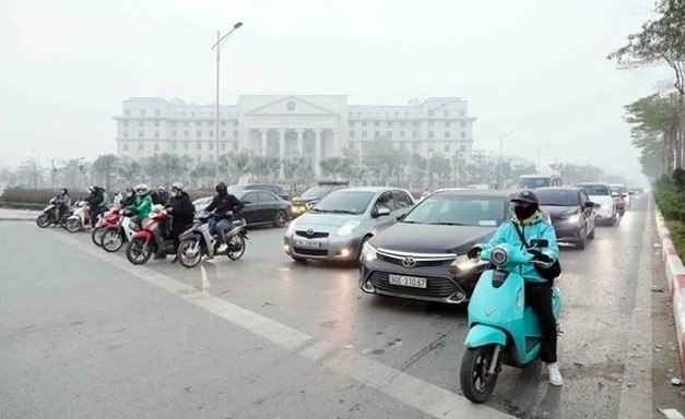 People comply with traffic signals at an intersection in Hanoi.