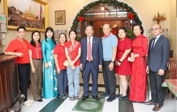 Ambassador Nguyen Minh Tam (5th from right) and the family of Le Dung, former president of the Vietnamese Association in Vientiane