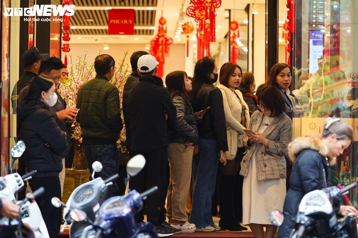 People wait patiently in line as they prepare to enter Phu Quy shop to purchase gold.