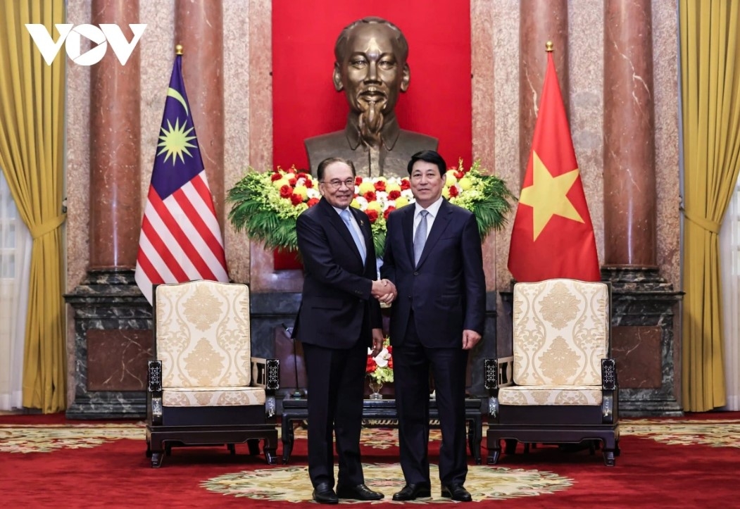 Vietnamese State President Luong Cuong (R) welcomes Malaysian Prime Minister Anwar Ibrahim.