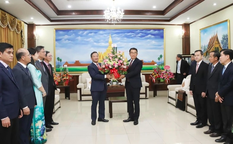 Vietnamese Ambassador Nguyen Minh Tam presents flowers from Party General Secretary To Lam to congratulate the 70th anniversary of the Lao People's Revolutionary Party. (Photo: VNA)
