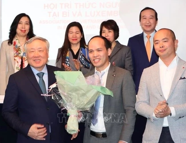 Permanent Deputy Prime Minister Nguyen Hoa Binh (first, left, front) presents flowers to ViLaB leader
