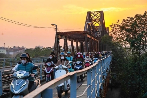 Motorcyclists cross the bridge.