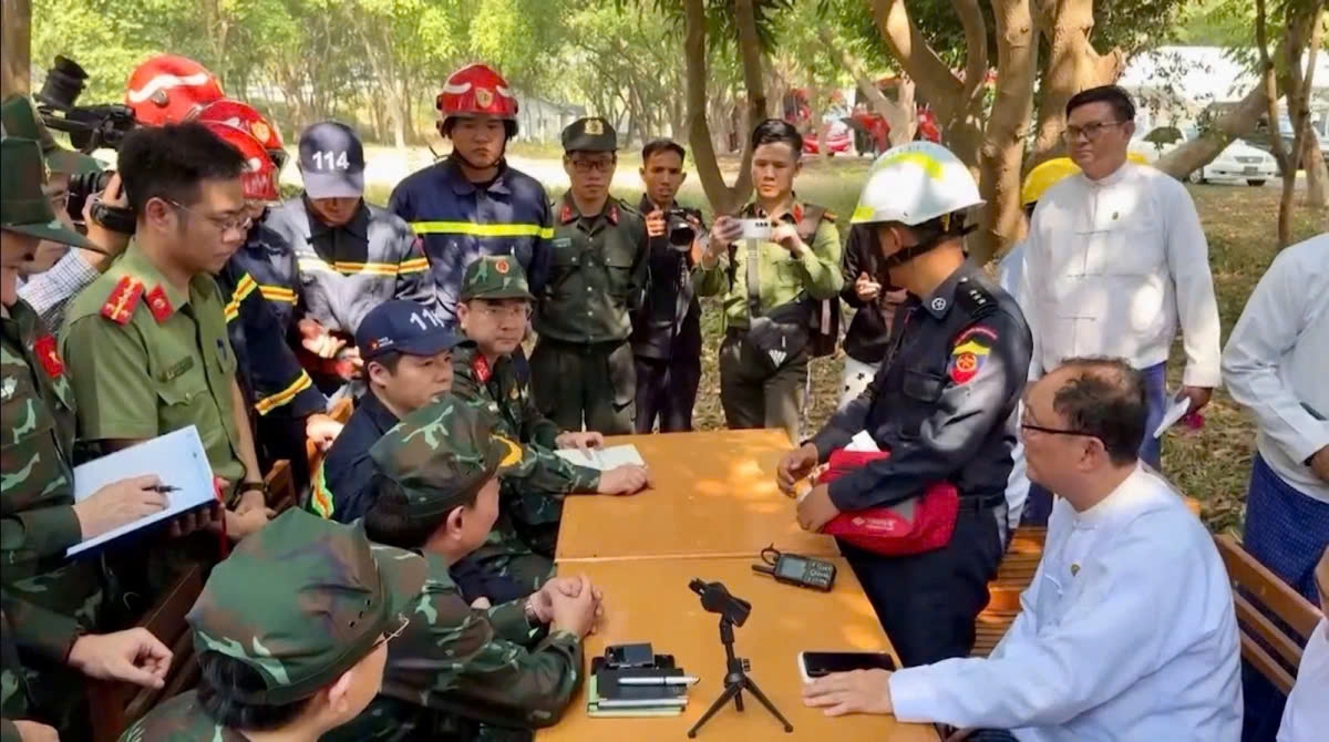 Vietnamese and Myanmar officers discuss rescue and relief strategies at the disaster site.