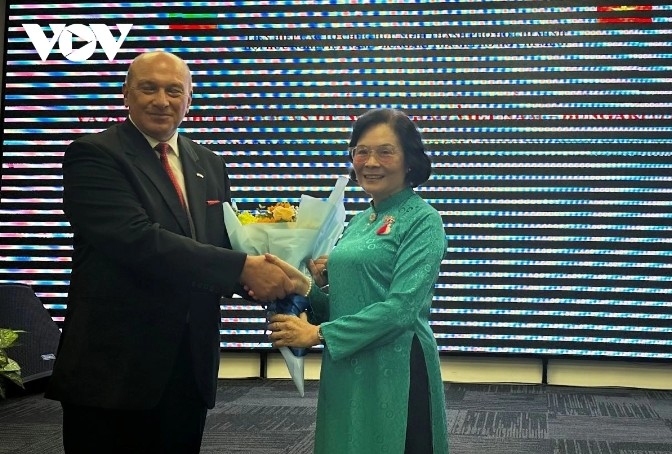 Hoang Thai Lan, chairwoman of the Association, presents flowers to Oleg Marinov, Economic and Trade Counselor at the Bulgarian Embassy in Vietnam