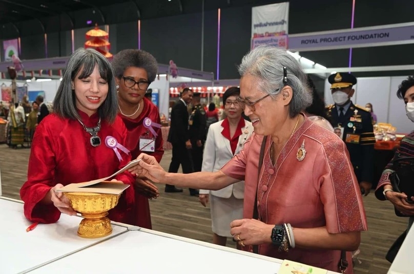 Ho Thi Thu Trang (left), spouse of the Vietnamese Ambassador to Thailand, invites Thai Princess Maha Chakri Sirindhorn to a lottery ticket of the bazaar.