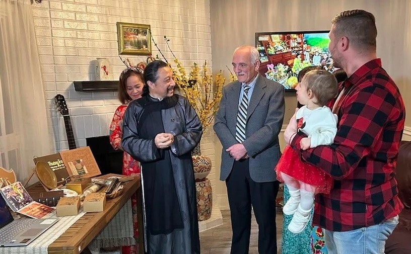 Artisan Nguyen Ngoc Tuan (in traditional ao dai) introduces Vietnamese tea to foreign friends