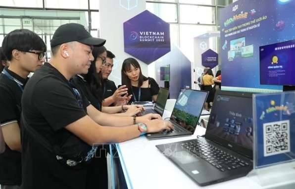Visitors to a booth introducing technology products at the Vietnam Blockchain Summit 2022.
