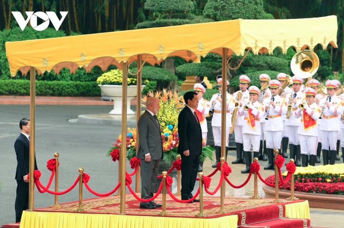 The two State leaders stand on the podium while military bands play the national anthems of both nations.