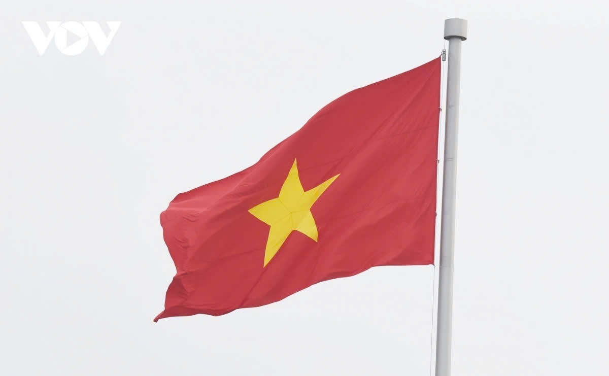 The national flag of Vietnam is raised on the flagpole, symbolizing the strength and unity of the nation.