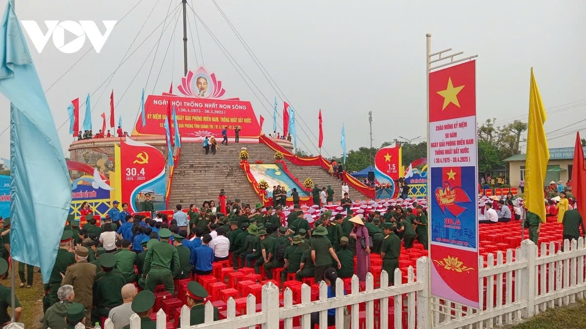 At exactly 7:00 AM, the red and yellow star flag fly proudly above the Hien Luong Flag Tower, accompanied by the national anthem playing loudly, against the backdrop of bright red flags.