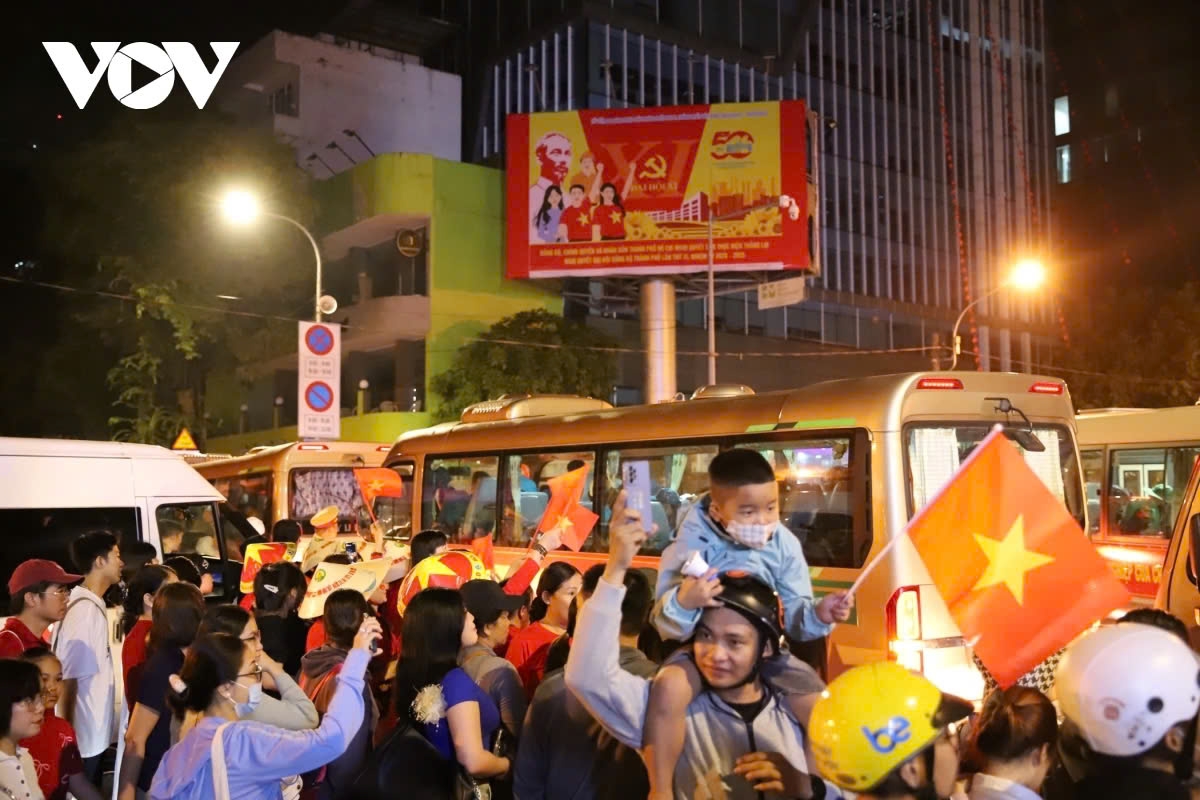 Those who cannot enter to watch the parade wave and greet the vehicles carrying the soldiers as they pass by.