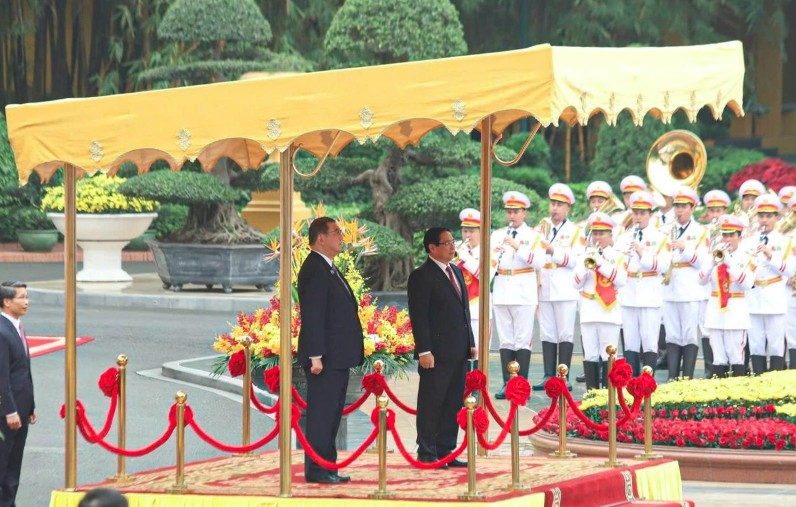 Prime Ministers Pham Minh Chinh and Ishiba Shigeru stand on the podium as the national anthems of Vietnam and Japan are played.
