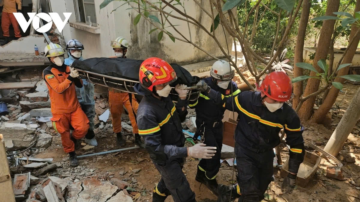 Vietnamese rescue workers retrieve a dead body of a 15-year-old boy from rubble in Myanmar