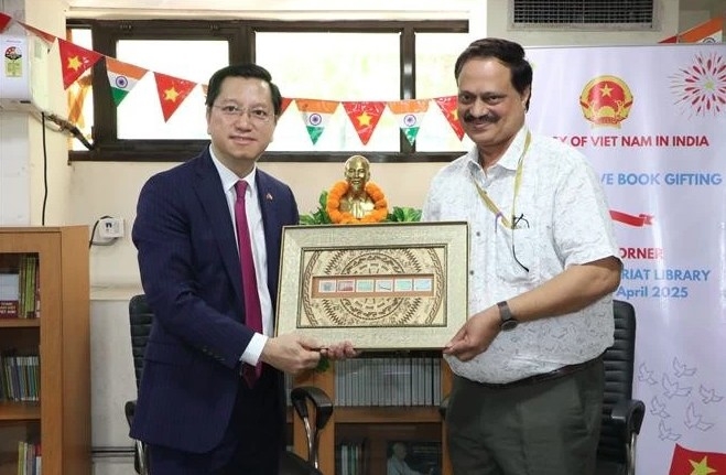 Ambassador Nguyen Thanh Hai (left) presents the representative of the Indian Central Secretariat Library with a picture of Vietnamese stamps.