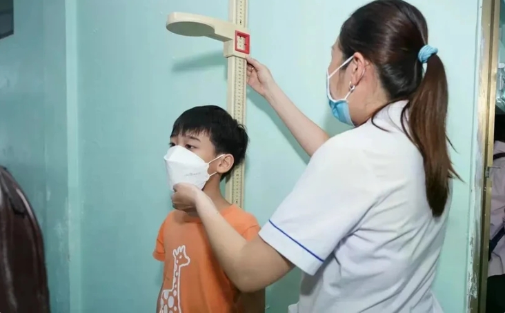 A health worker measures a boy's height as part of a screening programme to promptly detect children with malnutrition problems. (Photo: vtv.vn)