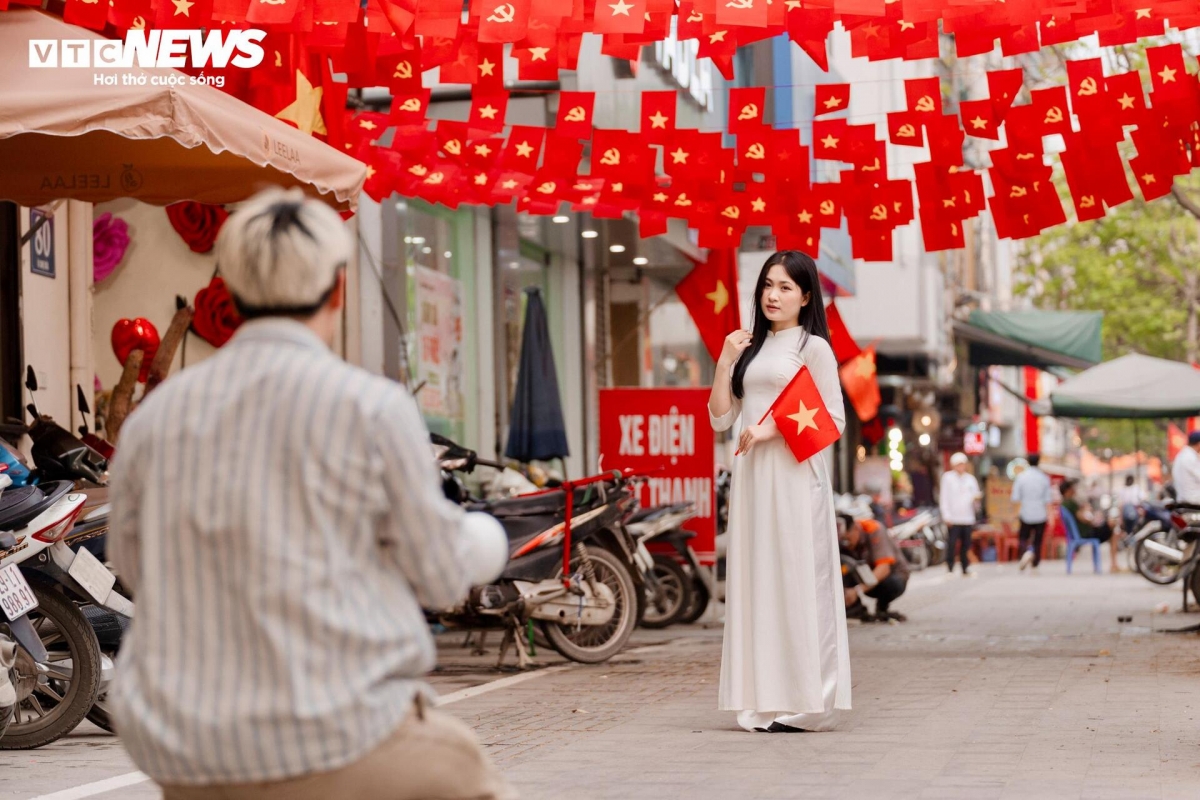 Young people pose with Ao Dai (national dress) and national flags to celebrate the event.
