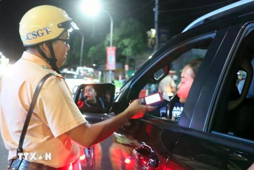 A police officer in Long Xuyen city conducts random breathalyser tests on a motorist