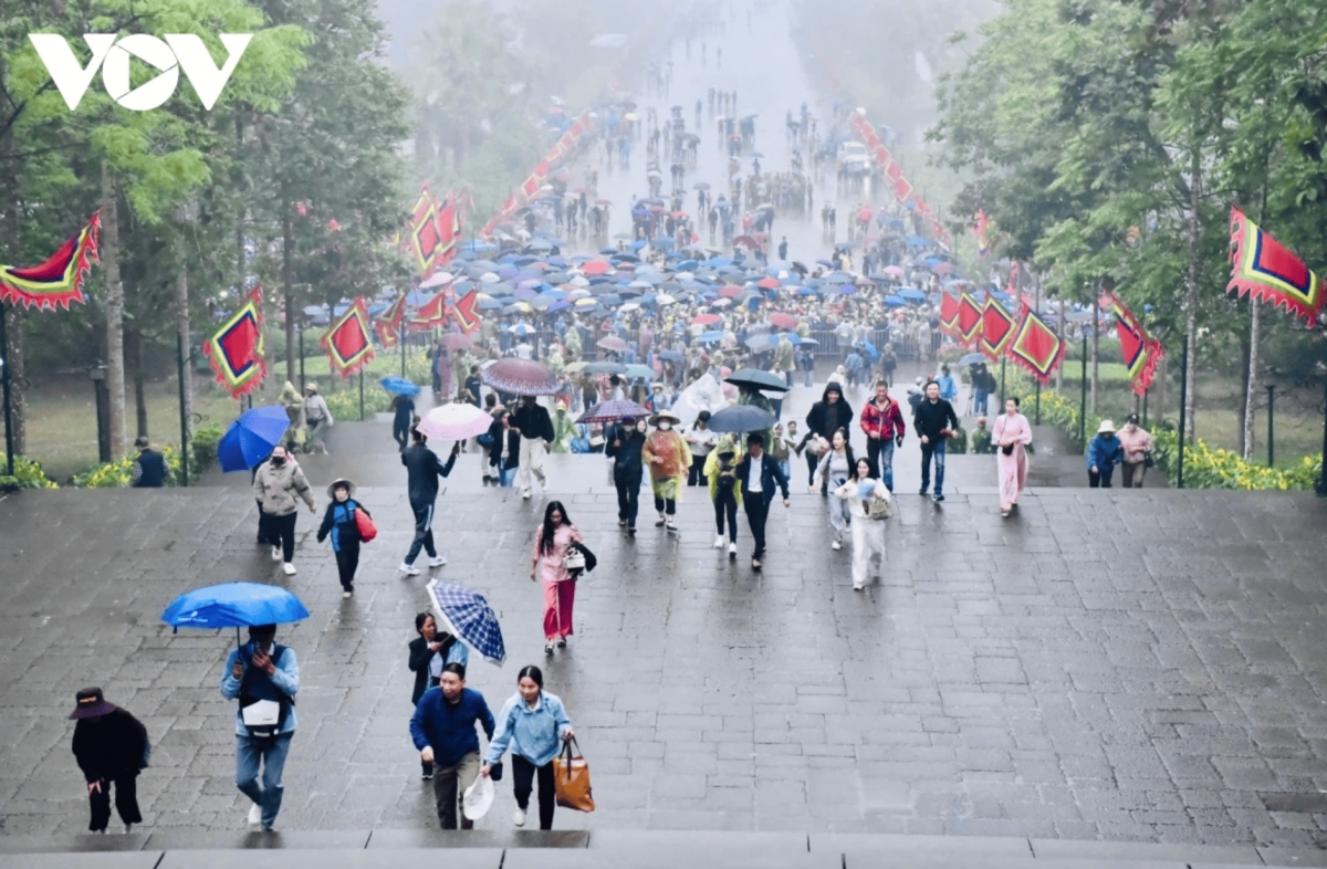 Despite scattered rainfall, at the Hung Temple historical relic site in the northern province of Phu Tho, hordes of people and tourists gather early in the day to offer incense in commemoration of the Hung Kings.