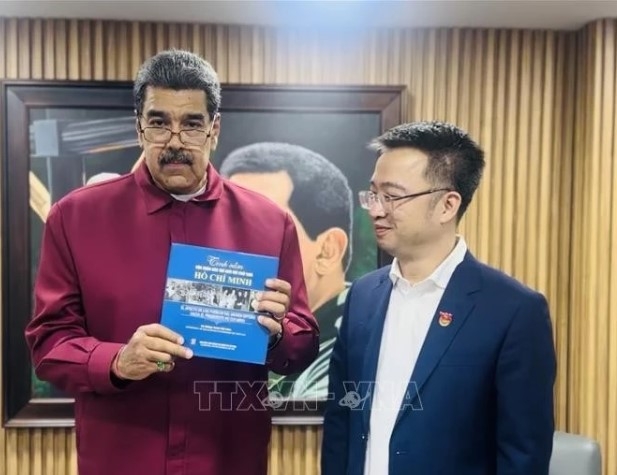 Venezuelan President Nicolas Maduro (L) receives the Spanish edition of "The world's affection for President Ho Chi Minh" from Nguyen Tuong Lam, Secretary of the Ho Chi Minh Communist Youth Union Central Committee. (Photo: Vietnamese Embassy in Venezuela)