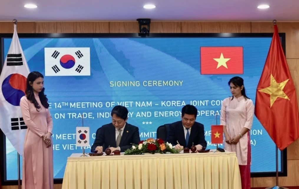 Vietnamese Minister of Industry and Trade Nguyen Hong Dien (R) and Korean Minister of Trade, Industry and Energy Ahn Dukgeun sign cooperation documents in the meeting.