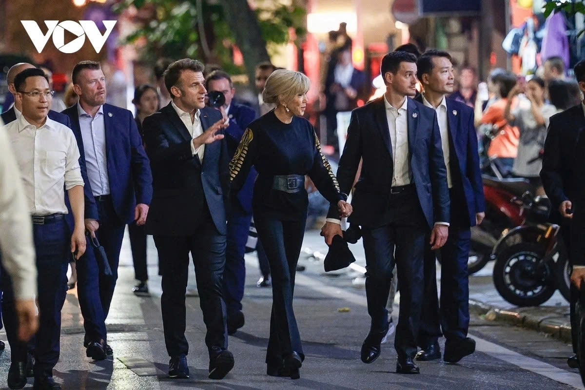 Dressed casually, President Macron and his spouse stroll along Trang Tien, Hang Khay, and Nha Chung streets, drawing attention from many locals and tourists.