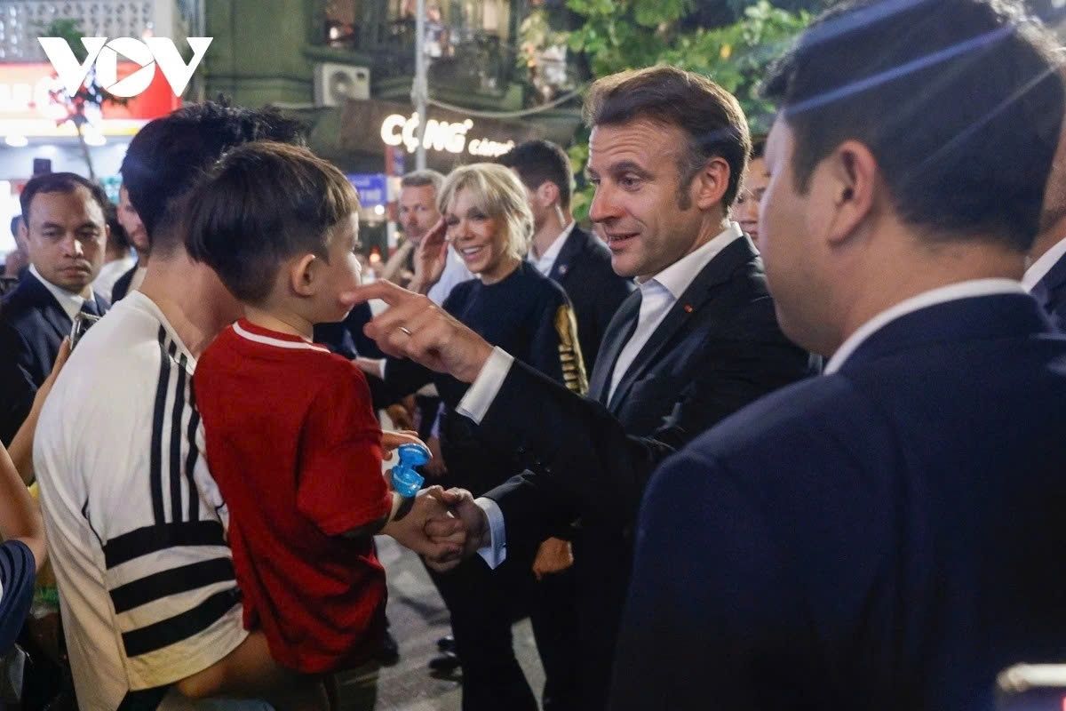 President Macron and his spouse chat, take photos, and warmly interact with local residents.