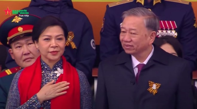 General Secretary To Lam and his spouse salute the Vietnamese troops as they march past the grandstand
