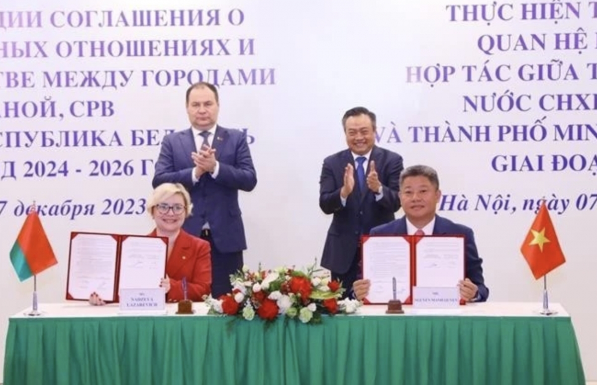 Belarusian Prime Minister Roman Golovchenko (standing, left) and Chairman of the Hanoi People's Committee Tran Sy Thanh witness the signing of the cooperation programme to implement the agreement on friendship and cooperation between Hanoi and Minsk in 2023. (Photo: VNA)