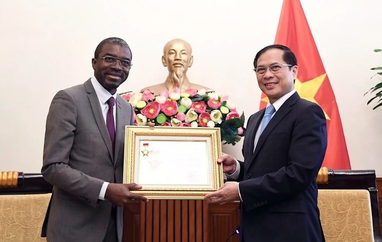 Deputy Prime Minister and Foreign Minister Bui Thanh Son awards Lazare Eloundou Assomo, Director of the UNESCO World Heritage Centre, the “For the Cause of Vietnam’s Diplomacy” insignia at their meeting on May 19. (Photo: Baochinhphu.vn)