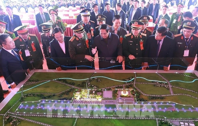 Prime Minister Pham Minh Chinh (front, fourth from right) and officials view a model of the Gia Binh Airport project (Photo: VNA)