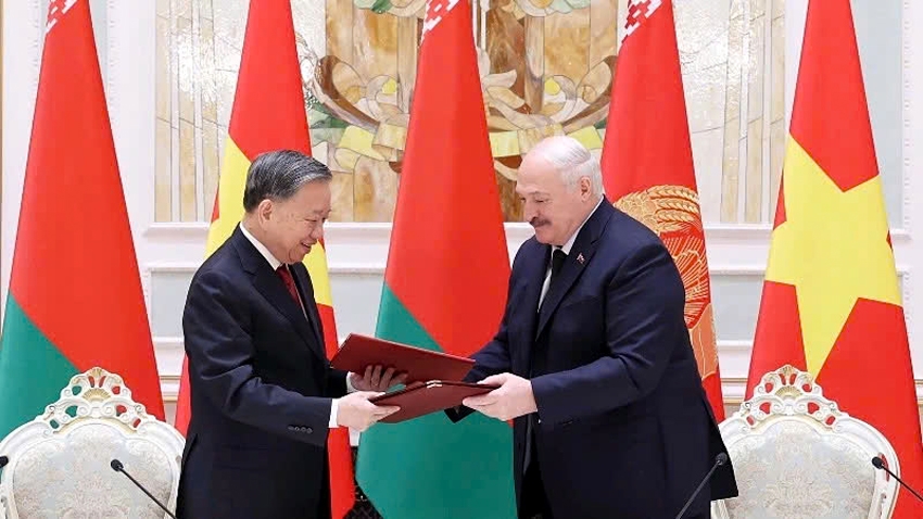 Party General Secretary To Lam (L) and President Alexander Lukashenko exchange the signed joint statement on the establishment of the strategic partnership between Vietnam and Belarus in Minsk on May 12