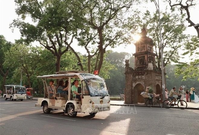 Tourists travel around Hoan Kiem Lake by electric cars.