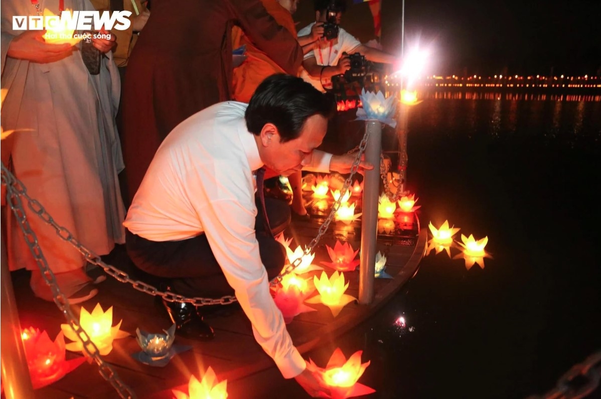 Minister of Ethnic and Religious Affairs Dao Ngoc Dung drops lotus-shaped lanterns into the lake, praying for world peace, happiness, and prosperity.