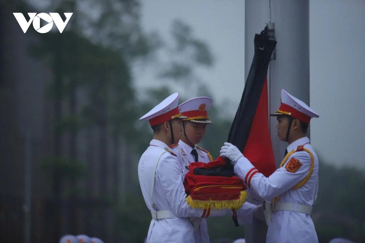 A black ribbon is attached to the national flag during the flag salute ceremony at Ba Dinh Square.