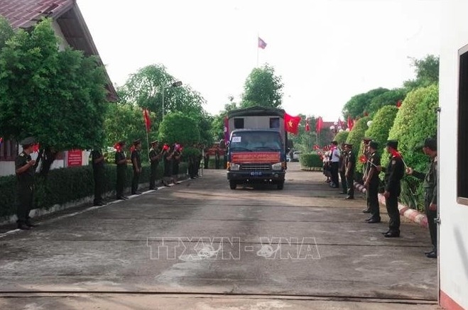 Lao military personnel and local people bid farewell as the remains of Vietnamese volunteer soldiers and experts are repatriated.
