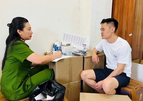 Pham Ngoc Tien is questioned by a police officer. (Photo: daibieunhandan.vn)