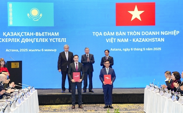 Vietjet CEO, Dinh Viet Phuong (right), and Qazaq Air CEO, Adilbek Umraliyev, exchange the cooperation agreement, witnessed by Vietnam's Party General Secretary To Lam, Kazakhstan's Deputy Prime Minister Yermek Kosherbayev, and Vietnam's Deputy Prime Minister and Foreign Minister Bui Thanh Son. (Photo courtesy of Vietjet) 
