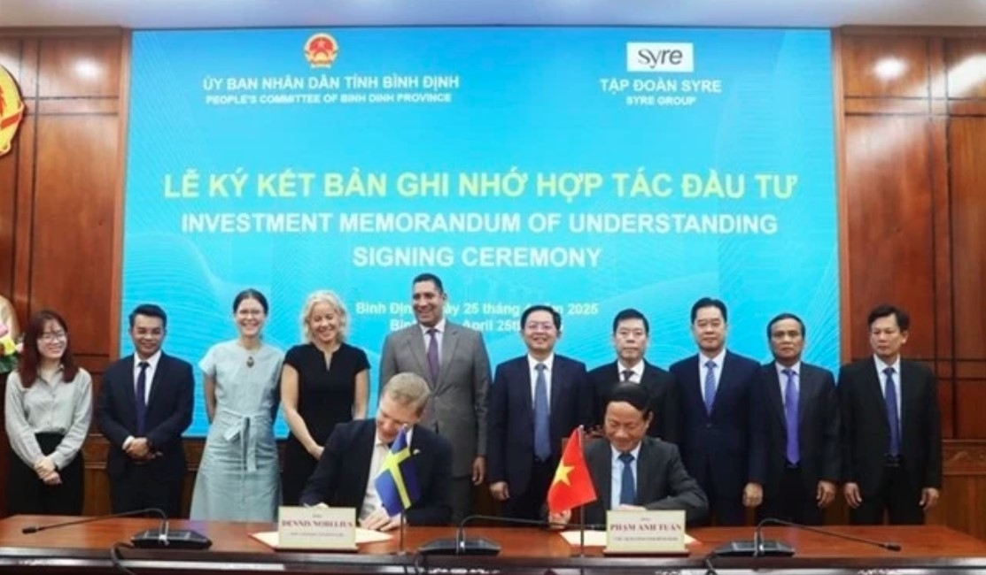 Chairman of the Binh Dinh provincial People’s Committee, Pham Anh Tuan (sitting, right), and the CEO of Syre Group sign a memorandum of understanding on investment cooperation on April 25. (Photo: nld)