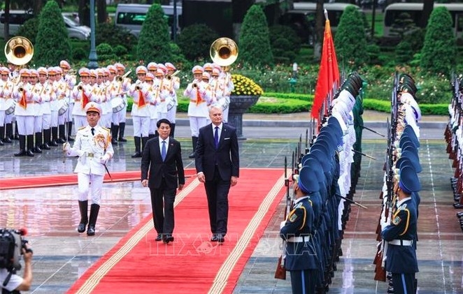 President Luong Cuong and his Lithuanian counterpart Gitanas Nauseda review the Vietnam People's Army honor guard. (Photo: VNA)