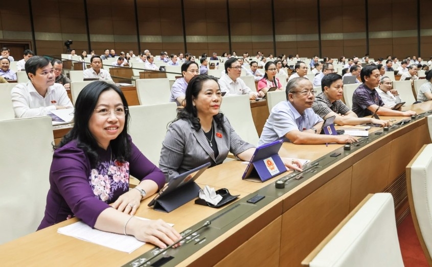 NA deputies press buttons to pass the resolution on provincial-level administrative restructuring in 2025.