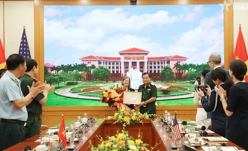 Deputy Defence Minister Senior Lieutenant General Hoang Xuan Chien (R) presents a certificate of merit from the Minister of National Defence of Vietnam to USAID's Mission Director for Vietnam Aler Grubbs (Photo: VNA)