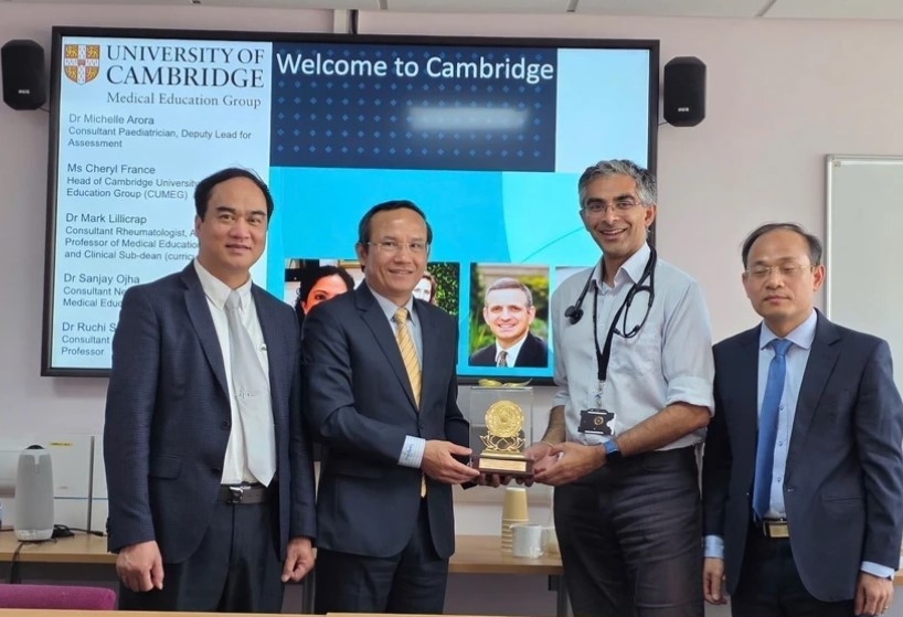 Director of the 108 Military Central Hospital Major General, Professor, Dr Le Huu Song (second, left), presents a souvenir to a representative of University of Cambridge School of Clinical Medicine.