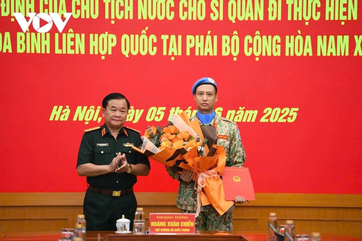 Senior Lieutenant General Hoang Xuan Chien (L), Deputy Minister of National Defence, presents the President's decision appointing Major Tran Viet Cuong from the Armoured Corps as Military Observer at the United Nations UN Mission in South Sudan (UNMISS)
