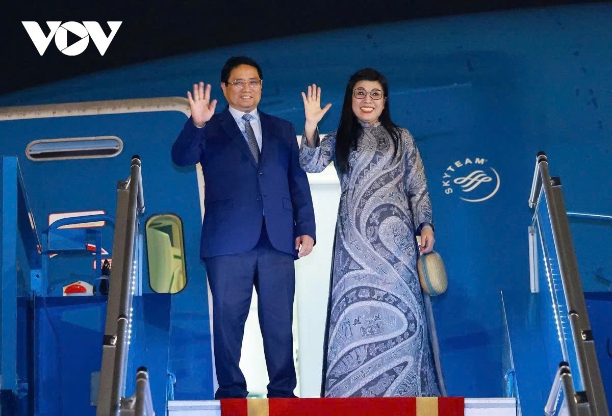 Prime Minister Pham Minh Chinh and his spouse wave their hands before boarding the aircraft to depart from Hanoi early on June 5, beginning a nine-day working trip to France, Sweden and Estonia