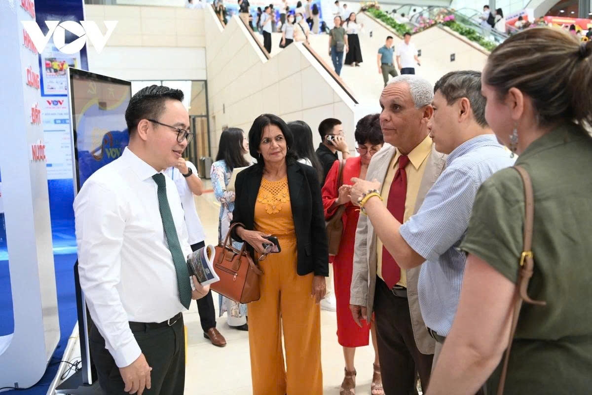 Pham Manh Hung, vice president of VOV, receives foreign delegates to the exhibition area.