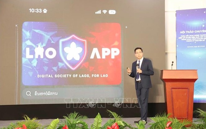 A representative of Star Telecom (Unitel) presents a digital payment solution to promote e-commerce between Vietnam and Laos. (Photo: VNA) 