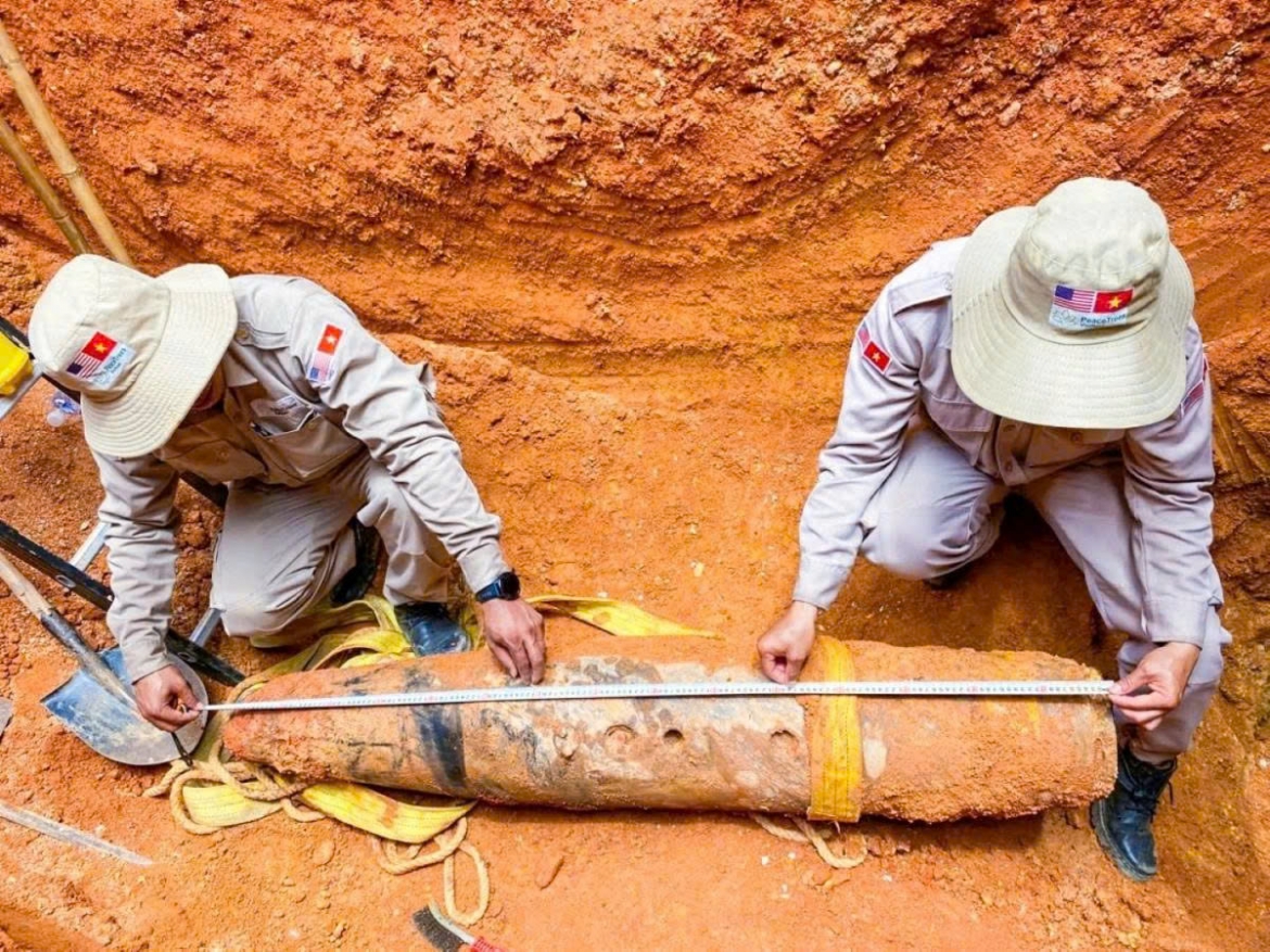 PeaceTrees Vietnam Project experts measure the wartime bomb before transporting it to a designated site for disposal